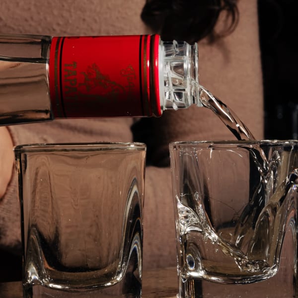 A bottle of Tapatio tequila pours a clear liquid into two shot glasses at Tipsea bar.