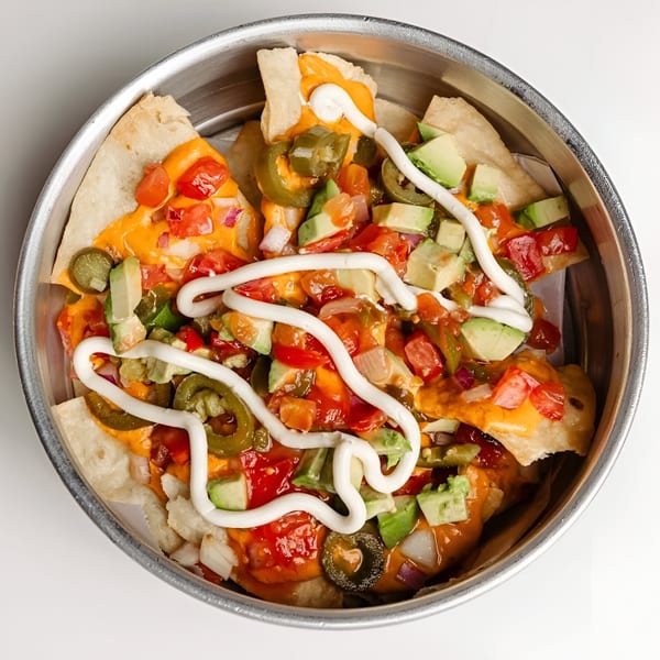 Tipsea's nachos with melted cheese, diced tomatoes, avocado, jalapeños, and a drizzle of white sauce.